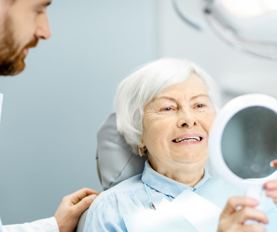 patient looking in mirror with dentist from smile studio in nottingham after having dentures fitted